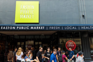 A crowd of students stands in front of the Easton Public Market 