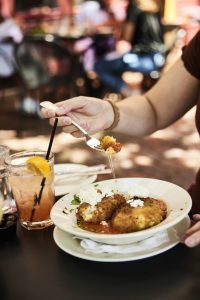 A diner digs into arancini at Sette Luna.