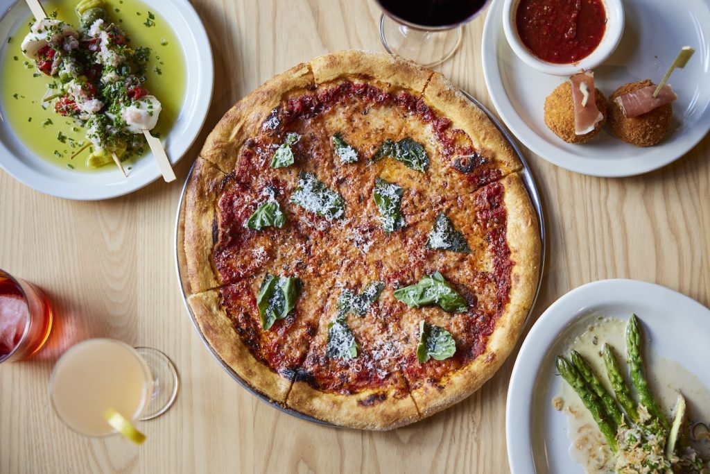 An aerial view is show with a pizza, drinks and appetizers from Bar Torino.